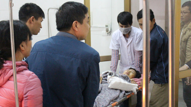 Nạn nhân Nguyễn Thị Lý đang được người nhà và bác sĩ đưa đi điều trị sau khi cấp cứu - Ảnh: CHÍ TUỆ
