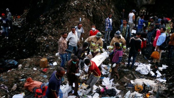 Nhân viên cứu hộ đưa thi thể nạn nhân vừa được kéo ra khỏi vụ sụp bãi rác ở Ethiopia - Ảnh: Reuters