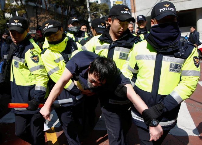 Cảnh sát bắt giữ người đàn ông ném chai nước vào 2 nhà báo - Ảnh: Reuters