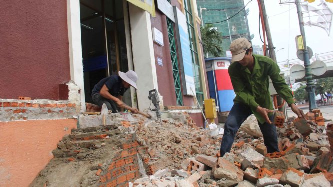 Không đợi đến hạn chót, chủ một tòa nhà trên đường Bạch Đằng đã tự xử phần xây lấn chiếm - Ảnh: Trường Trung