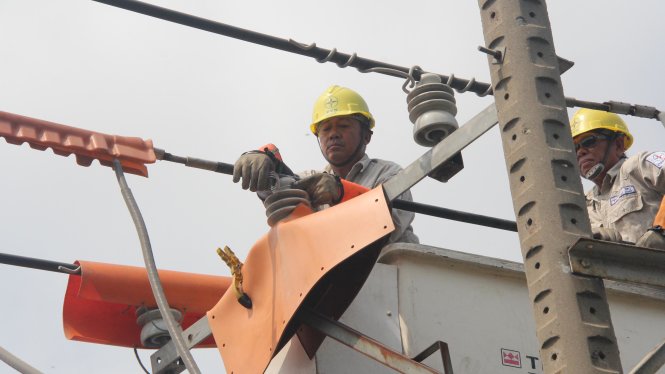 Công nhân Tổng công ty điện lực TP.HCM sửa chữa điện bằng công nghệ hotline (không cúp điện) - Ảnh Q.Khải