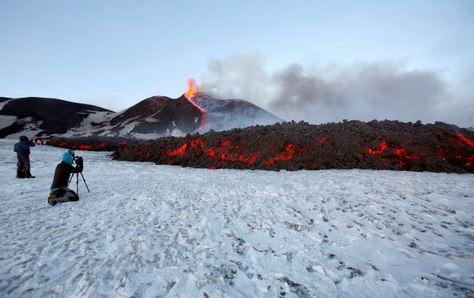 Du khách tiếp cận dòng dung nham của núi lửa Etna và chụp ảnh - Ảnh: Reuters