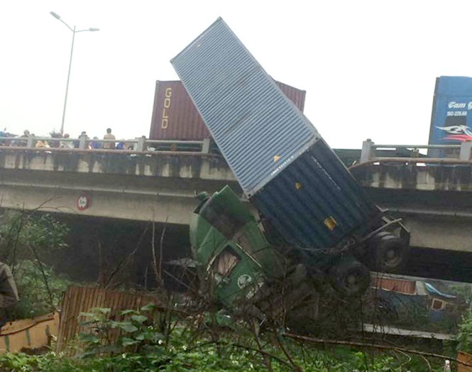 Xe container đầu cắm xuống đất, thùng xe treo lơ lửng trên thành cầu Thanh Trì - Ảnh: Otofun