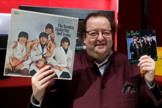 Nhà sưu tập Jacques Volcouve cầm trên tay các đĩa nhạc của The Beatles mà ông bán đấu giá  - Ảnh: Reuters
