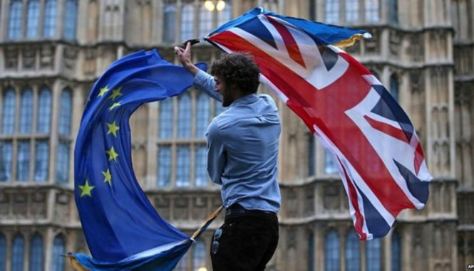 Một người cầm cờ Anh và EU - Ảnh: BBC
