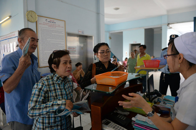 Người dân nộp sổ bảo hiểm y tế khám bệnh tại Bệnh viện Q.Bình Thạnh, TP.HCM - Ảnh: HỮU KHOA