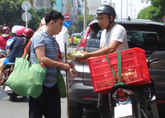 Anh Đỗ Trọng Nhân cùng người anh họ và người bạn chở cơm đi trao cho những người có hoàn cảnh khó khăn - Ảnh: Thái Hoàng