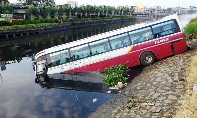 Chiếc xe khách lọt xuống kênh Tàu Hủ sau vụ tai nạn - Ảnh: Lê Phan