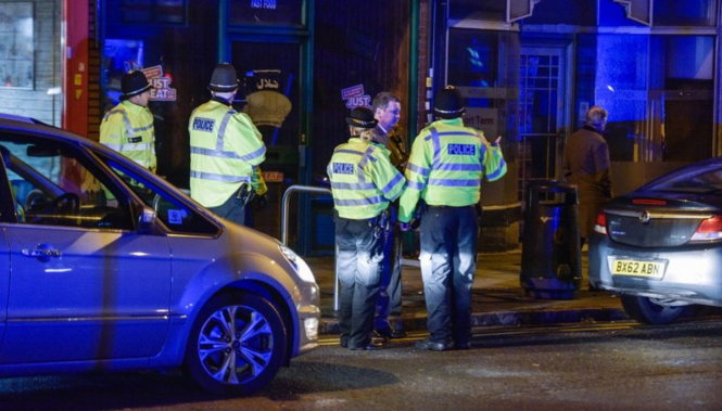 Cảnh sát đứng bên ngoài căn hộ ở Birmingham - nơi diễn ra vụ vây bắt - Ảnh: Caters