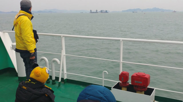 Thân nhân các nạn nhân vẫn còn mất tích đang theo dõi hoạt động trục vớt phà Sewol từ xa - Ảnh: AFP