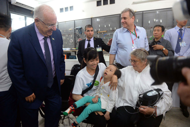 Tổng thống Israel Reuven Ruvi Rivlin và Phu nhân Nechama Rivlin thăm hỏi sức khoẻ bé Vũ Phương Uyên bị bệnh bại não tại dự án xã hội hỗ trợ cho người khuyết tật tại Q.2 - Ảnh: HỮU KHOA