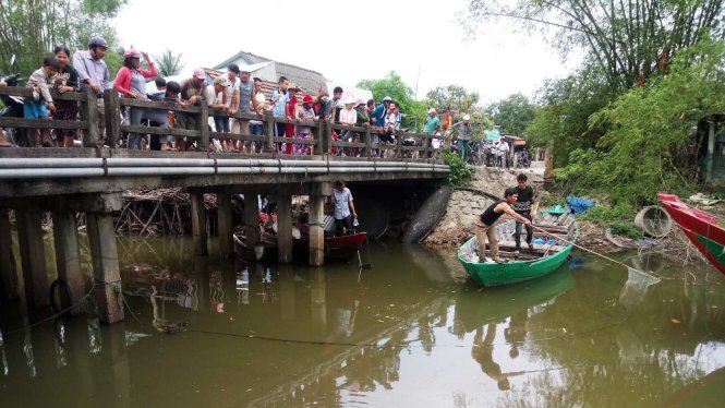 Người dân ở xã Lộc Vĩnh hiếu kỳ tập trung xem vớt cá chết ở khu vực sông Bình An (xã Lộc Vĩnh, huyện Phú Lộc) sáng 24-3 - Ảnh: Đ.Thành