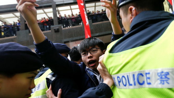 Thủ lĩnh phong trào đòi dân chủ của người trẻ Hong Kong Joshua
Wong (Hoàng Chi Phong) cùng bạn bè xuống đường biểu tình ở gần
nơi diễn ra cuộc bỏ phiếu sáng 26-3 - Ảnh: Reuters