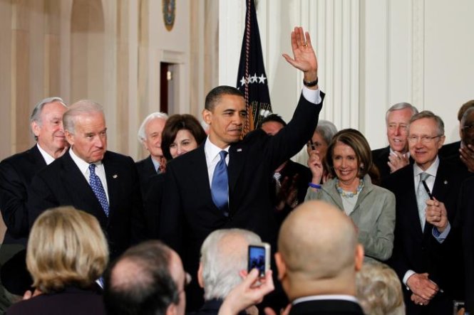 Tổng thống Obama vẫy tay chào mọi người sau khi ký Obamacare tại Nhà Trắng ngày 23-3-2010 - Ảnh: Reuters
