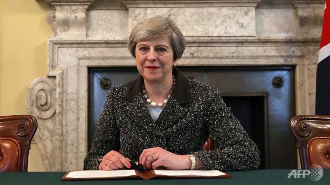 Bà Theresa May ký vào lá thư gởi cho Chủ tịch Hội đồng châu Âu Donald Tusk để thông báo kích hoạt Brexit - Ảnh: AFP
