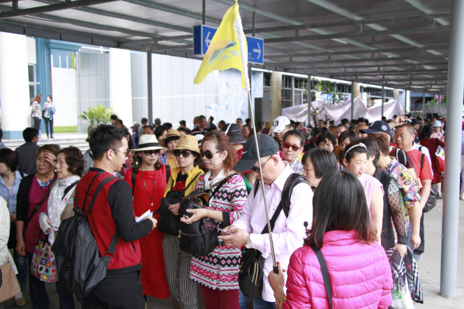 Một hướng dẫn viên du lịch phát vé cho khách Trung Quốc tham quan vịnh Hạ Long, Quảng Ninh - Ảnh: Đức Hiếu