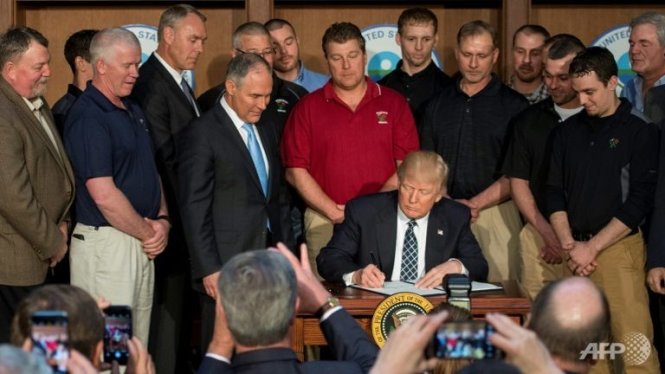 Vây quanh bởi các thợ mỏ than, tổng thống Donald Trump (giữa) ký sắc lệnh Độc lập Năng lượng tại trụ sở Cơ quan Bảo vệ Năng lượng ở Washington DC - Ảnh: AFP