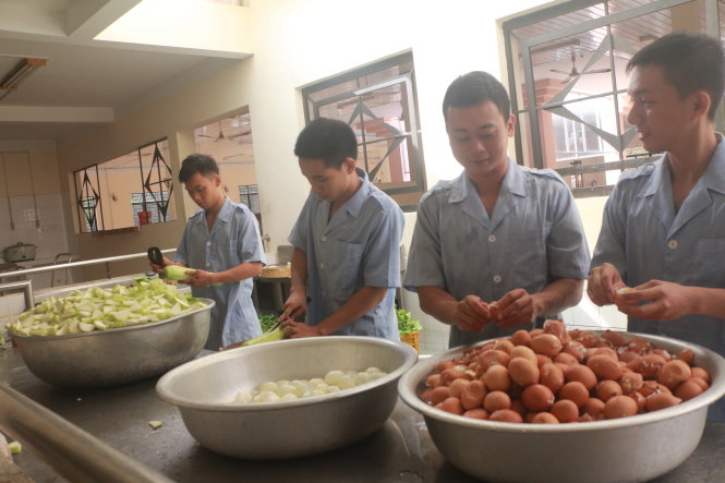 Từ những bạn trẻ ít khi làm việc nhà, giờ đây họ đã trở thành những anh nuôi lo việc ăn uống cho hàng trăm tân binh - Ảnh: Công Nhật