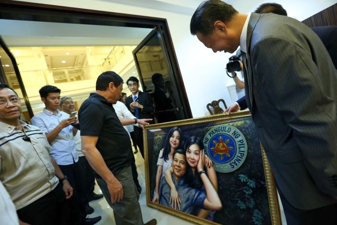 Tổng thống Philippines Rodrigo Duterte (thứ ba từ trái sang) xem bức tranh do đại sứ Trung Quốc tại Philippines Zhao Jinhua tặng ngày 27-3 - Ảnh: Phủ tổng thống Philippines