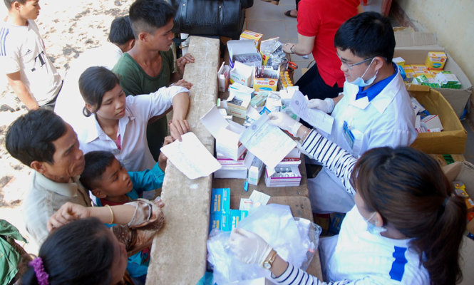 Các y bác sĩ thuộc Hội LHTN tỉnh Quảng Trị phát thuốc miễn phí cho đồng bào Bru Vân Kiều sau khi khám - Ảnh: QUỐC NAM