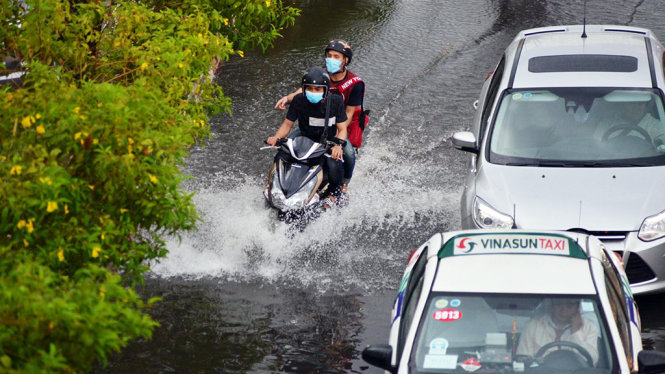 Nước ngập tại làn xe ôtô trên đường Phạm Văn Đồng - Ảnh: LÊ PHAN