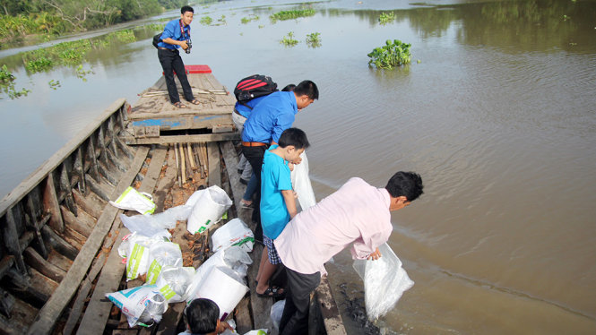 Nhiều đoàn viên thanh niên, người dân tham gia thả cá giống xuống sông Ba Lai - Ảnh: Mậu Trường