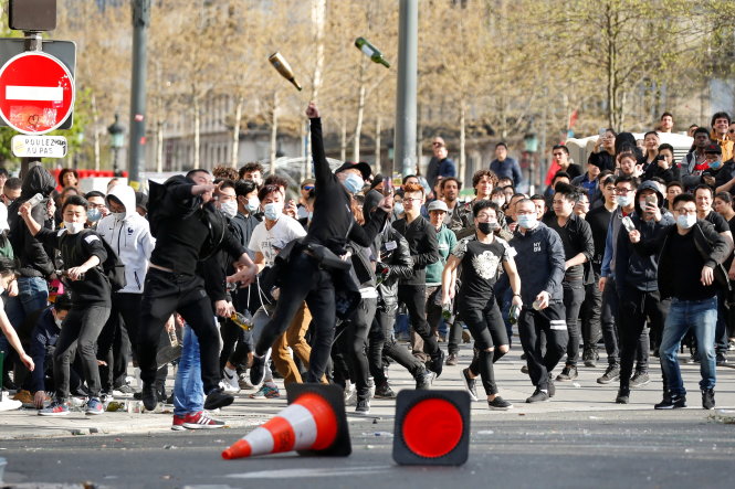 Nhiều người trẻ đã tham gia cuộc biểu tình của người Trung Quốc tại Paris chiều 2-4 và họ đã ném đồ vật vào lực lượng chức năng - Ảnh: Reuters