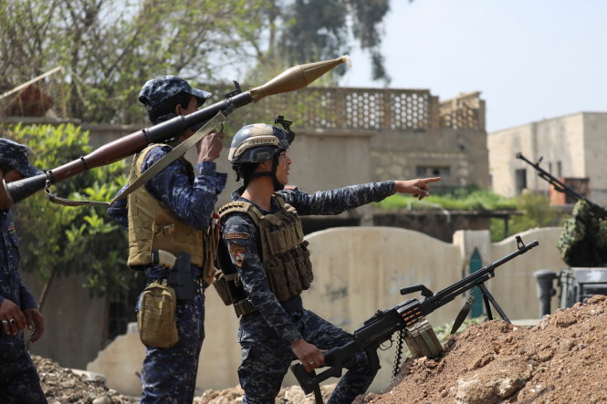 Lực lượng cảnh sát liên bang Iraq bên chiến hào dựng tạm trên đường phố Mosul, ngày 2-4. Lực lượng Iraq với sự hỗ trợ của Mỹ đang giành từng tấc đất với lực lượng khủng bố Nhà nước Hồi giáo (IS) ở Mosul - Ảnh: Reuters