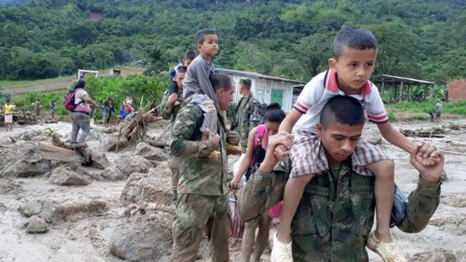 Binh sĩ Colombia giúp trẻ em sơ tán - Ảnh: EPA
