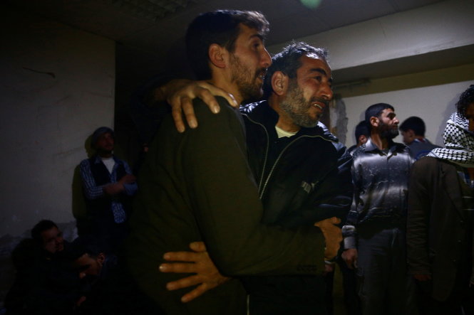 Người dân ở thành phố Douma, ngoại ô Damascus, khóc ngất khi người thân thiệt mạng cho bom đạn ngày 3-4 - Ảnh: Reuters