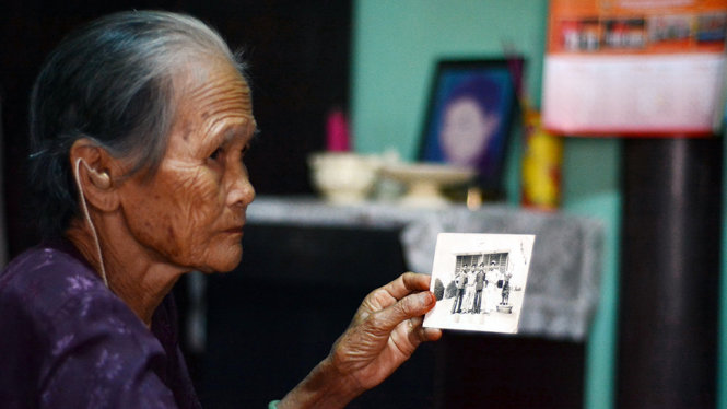 Bà Nguyễn Thị Lanh, mẹ của liệt sĩ Trần Văn Khanh, nâng niu tấm ảnh con mình - Ảnh: ĐỨC TRONG