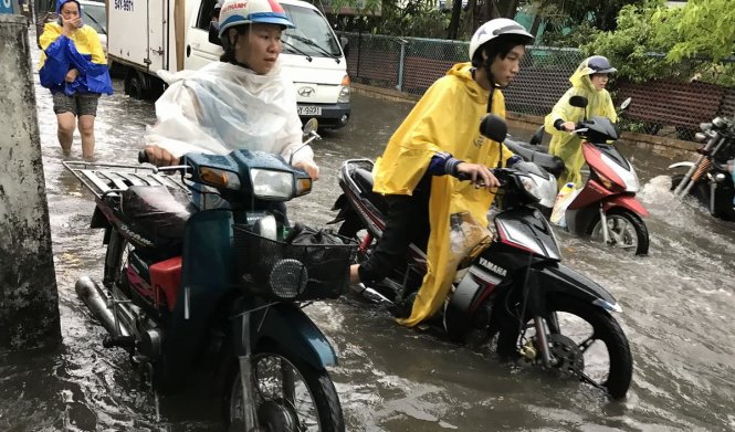 Nhiều người bì bõm lội nước sau trận mưa trái mùa đầu tháng 4 trên đường Lê Đức Thọ, Q.Gò Vấp - Ảnh Q.Khải