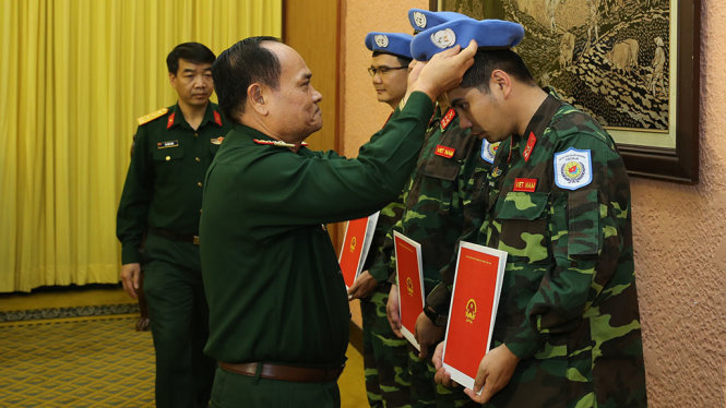 Thượng tướng Nguyễn Phương Nam trao quyết định và đội mũ nồi xanh cho 3 sĩ quan nhận nhiệm vụ - Ảnh: KHỔNG MINH KHÁNH