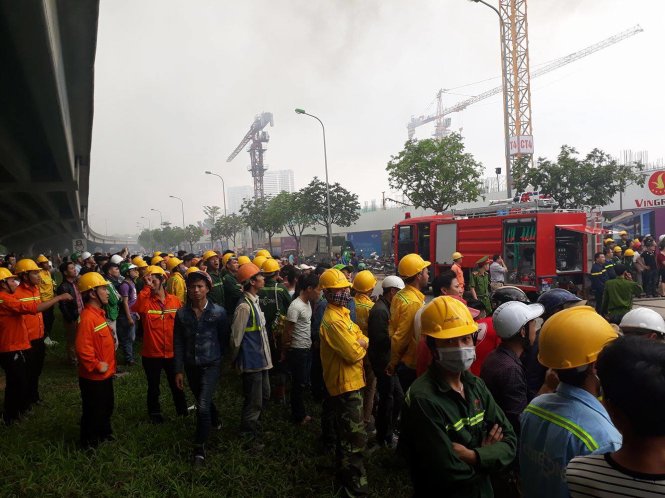 Hàng trăm công nhân đang lo lắng theo dõi chữa cháy ở khu vực bên ngoài - Ảnh: Quang Thế