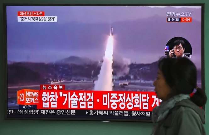 Một phụ nữ đi qua màn hình ti vi đang phát bản tin về vụ phóng tên lửa của CHDCND Triều Tiên tại nhà ga xe lửa ở Seoul, Hàn Quốc ngày 5-4-2017 - Ảnh: AFP