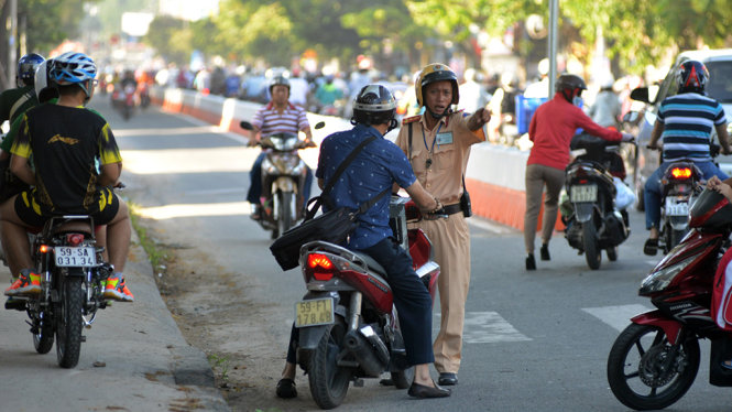 Lực lượng Cảnh sát giao thông hướng dẫn cho người dân quay đầu đi đúng lộ trình - Ảnh: Lê Phan