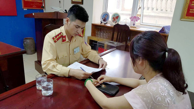 Một trong năm tài xế đi ngược chiều trên cầu Nhật Tân làm việc với cơ quan công an - Ảnh: T.Q.