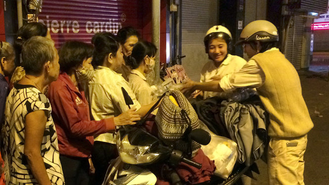 Bạn trẻ phát quần áo ấm và mền cho người nghèo trên đường Phan Đăng Lưu (Q.Phú Nhuận, TP.HCM) - Ảnh: Châu Anh
