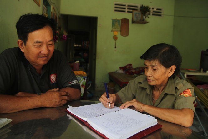 Bà Bảy Luôn bàn kế hoạch đi tuần tra cùng ông Nguyễn Văn Tâm - công an viên phụ trách ấp An Phú - Ảnh: MẬU TRƯỜNG