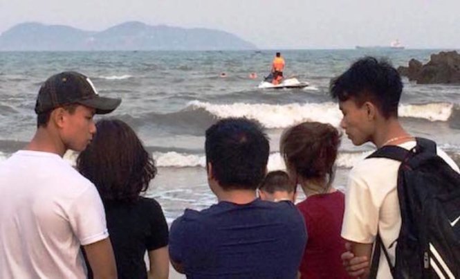 Người dân theo dõi lực lượng tìm kiếm cứu nạn tìm kiếm hai nam sinh bị sóng cuốn mất tích ở bãi biển Cửa Lò chiều 9-4 - Ảnh: Nghi Trung