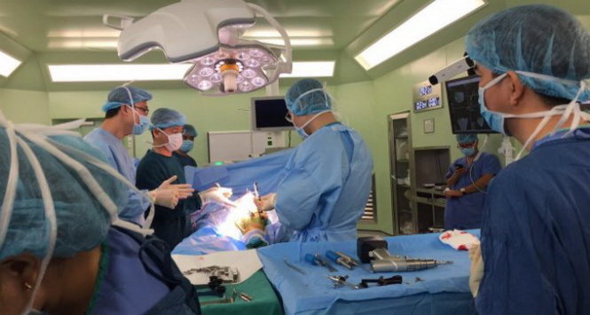 Các bác sĩ Bệnh viện Bạch Mai phẫu thuật cùng với sự hỗ trợ của robot - Ảnh: Thúy Anh