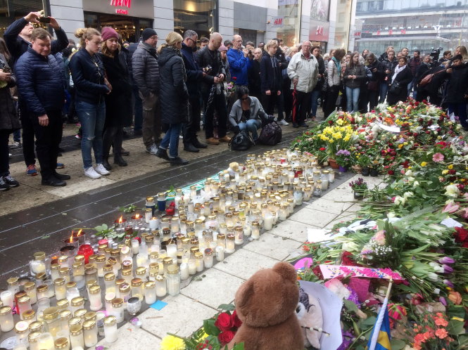 Người dân ở thủ đô Stockholm đặt nến và hoa tưởng niệm các nạn nhân, trong buổi lễ tổ chức ngày 10-4 - Ảnh: Reuters