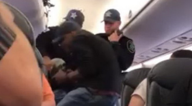 Hình ảnh nam hành khách bị nhân viên an ninh lôi xuống máy bay được chia sẻ trên mạng - Ảnh: BBC/TW