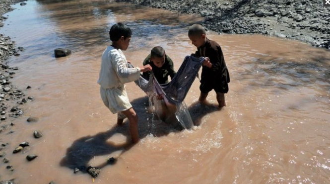Trẻ em bắt cá trong suối ở Afghanistan - nơi được nói là có nguồn cấp nước bị hạn chế và được đầu tư thuộc hàng kém nhất trên thế giới - Ảnh: AFP