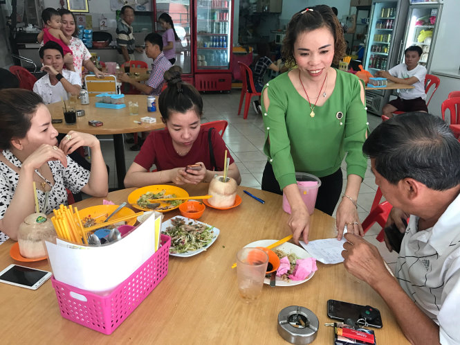 Chị Ngô Thị Hà (đứng) phục vụ khách tại quán ăn của gia đình ở làng Batu Kapar, thành phố Klang. Đa số phụ nữ Việt lấy chồng Malaysia gốc Hoa -
 Ảnh: Q.TR.