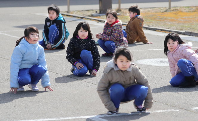 Học sinh tiểu học ở thành phố Oga (Nhật) tham gia tập sơ tán phòng tên lửa hôm 17-3 - Ảnh: Reuters