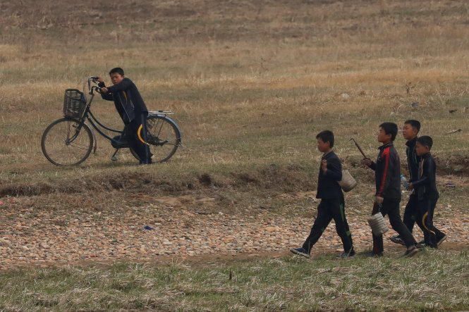 Trẻ em Triều Tiên đi bộ bên bờ sông Áp Lục, biên giới Trung - Triều ngày 15-4 - Ảnh: Reuters