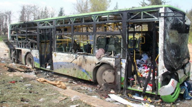 Chiếc xe buýt bị trúng bom chỉ còn trơ khung - Ảnh: AFP