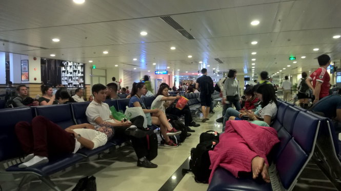 Hành khách mệt mỏi chờ chuyến bay. Ảnh: Thanh Hương