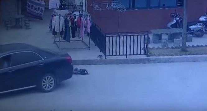 Bé trai bị chiếc xe tông ngã và cuốn vào gầm - Ảnh chụp từ clip